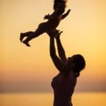 Mother and little daughter having fun on beach