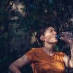 Woman drinking water outdoors
